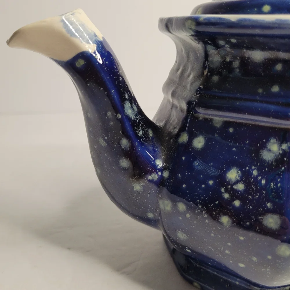 A blue and white speckled teapot. 271
